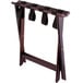 A Lancaster Table & Seating mahogany wood folding luggage rack with black straps.