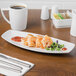 A white Schonwald porcelain long tray with shrimp and sauce on it.