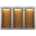 An Aarco satin anodized indoor lighted bulletin board cabinet with 3 glass doors.