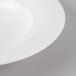 A close-up of a Schonwald white porcelain soup bowl with a white rim.