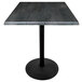 A Holland Bar Stool black steel laminate bar height table with a round black base and a black square top.