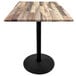A Holland Bar Stool rustic wood laminate table with a black base.