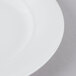 A Schonwald white porcelain plate with a curved edge and white rim.