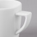 A close-up of a Schonwald white porcelain espresso cup with a handle.