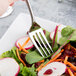 A Reserve by Libbey stainless steel salad fork in a salad with carrots and radishes.