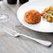 A plate of food with a Reserve by Libbey stainless steel dinner fork on a table.
