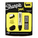 A black and yellow box of 12 Sharpie Magnum black markers with black caps.