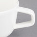 A close up of a white Villeroy & Boch porcelain cup with a handle.