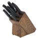 A Dexter-Russell knife block with black handles holding seven knives.