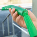 A person using a Unger UnitecLite window squeegee with a green handle.