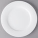 A Villeroy & Boch white porcelain plate with a round edge on a gray surface.