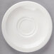 A white Villeroy & Boch porcelain saucer with a circular pattern on a gray surface.