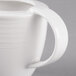 A close-up of a white Villeroy & Boch porcelain creamer with a handle.