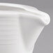 A close up of a Villeroy & Boch white porcelain creamer with a handle.