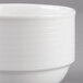 A close up of a white Villeroy & Boch porcelain stackable cup with a white rim.