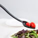 A black Cambro salad bar spoon with a red tomato on it.