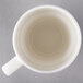 A close-up of a white Villeroy & Boch porcelain mug with a handle.
