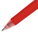 A close-up of a red Uni-Ball Signo Gel pen with a clear cap and silver tip.