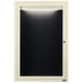 A white framed door with a black board and light behind it.