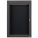 An Aarco bronze anodized aluminum cabinet with a black letter board and glass door with key lock.