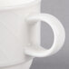 A close-up of a Villeroy & Boch white porcelain stackable cup with a handle.