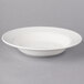 A Villeroy & Boch white porcelain deep plate with a curved edge on a gray background.