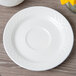 A white Villeroy & Boch Bella porcelain saucer on a white table.