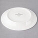 A white Villeroy & Boch porcelain saucer with a white rim and black text on it.