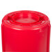 A red Rubbermaid BRUTE round plastic container with a lid.