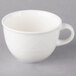 A Villeroy & Boch white porcelain cup with a handle on a gray surface.