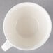 A Villeroy & Boch white porcelain cup with a handle on a gray surface.