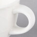 A close-up of a white porcelain Villeroy & Boch Bella cup with a handle.