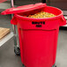 A red Rubbermaid BRUTE trash can with a lid open.