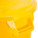 A yellow Rubbermaid trash can with a lid.