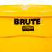 A yellow Rubbermaid Brute trash can with a lid.