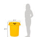 A woman standing next to a yellow Rubbermaid BRUTE trash can with a lid.