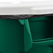 A green Rubbermaid BRUTE trash can with a white lid and black plastic bag inside.