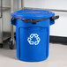 A blue Rubbermaid BRUTE recycling can with a blue lid.