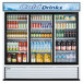 A white Turbo Air merchandising refrigerator with sliding glass doors filled with drinks and beverages.