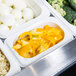 A white Cambro food pan with a tray of food, including broccoli and peppers.