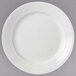 A close-up of a Libbey Galileo Lunar Bright white porcelain plate with a circular design.