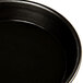A close up of a black Matfer Bourgeat tart/quiche pan.