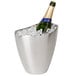 A champagne bottle in a Franmara stainless steel wine bucket full of ice on a bar table.