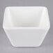 A white square Vollrath melamine bowl on a gray background.