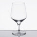 A close-up of a clear Reserve by Libbey Prism wine glass with a reflective surface.