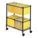 A black Safco two-tier rolling file cart with yellow file folders on a rack.