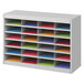 A gray Safco E-Z Stor file organizer on a white shelf with colorful papers.