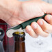 A hand using a Pulltap's Original dark green waiter's corkscrew to open a bottle.
