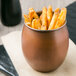 An American Metalcraft copper tumbler filled with french fries.