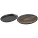 A round wooden plate with a walnut finish and a handle next to a black round pan with a handle.